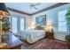 A bright bedroom features a queen bed, floral wallpaper, and shuttered windows at 2829 Seabreeze S Dr, Gulfport, FL 33707