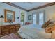 A bedroom showcasing a dresser, art and access to the exterior and en-suite bathroom at 2829 Seabreeze S Dr, Gulfport, FL 33707