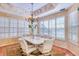Cozy dining room boasts a unique chandelier and plentiful light from the large shuttered windows and comfortable seating at 2829 Seabreeze S Dr, Gulfport, FL 33707