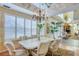 Elegant dining room featuring neutral decor, shuttered windows, and a decorative chandelier above a dining table for six at 2829 Seabreeze S Dr, Gulfport, FL 33707