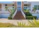 A captivating home entrance with elegant double doors, a grand staircase, and lush, manicured landscaping at 2829 Seabreeze S Dr, Gulfport, FL 33707