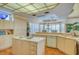 Open-concept kitchen with an island cooktop and bar seating in addition to a sunny dining area nearby at 2829 Seabreeze S Dr, Gulfport, FL 33707