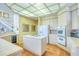 Well-equipped kitchen with an island cooktop, wall oven, and wine cooler with staircase in the background at 2829 Seabreeze S Dr, Gulfport, FL 33707
