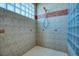 Enclosed shower with stylish glass block and tile, providing a modern and private space at 2829 Seabreeze S Dr, Gulfport, FL 33707