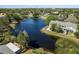 Beautiful aerial view of a home nestled by a serene lake, showcasing lush landscaping and neighborhood surroundings at 3056 Pepperwood W Ln, Clearwater, FL 33761
