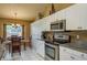 Bright eat-in kitchen featuring stainless steel appliances, granite countertops, and white cabinetry at 3056 Pepperwood W Ln, Clearwater, FL 33761