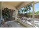 Screened patio shows a table and chairs, and view of palm trees and wood fence at 3056 Pepperwood W Ln, Clearwater, FL 33761
