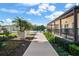 Scenic exterior view featuring manicured landscaping and a building with a wooden walkway that leads to a tennis court at 3435 Bayshore Blvd # 1401S, Tampa, FL 33629