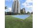 Full tennis court with a building and lush landscaping, providing privacy and a picturesque backdrop at 3435 Bayshore Blvd # 1401S, Tampa, FL 33629