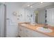 Bright bathroom featuring double sinks, a large mirror and access to the shower at 378 Tennessee Ave, Crystal Beach, FL 34681