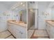 Bright bathroom featuring double sinks, a large mirror and access to the shower at 378 Tennessee Ave, Crystal Beach, FL 34681