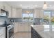Elegant kitchen featuring a stainless steel range, white cabinets, a tile backsplash, and an island with barstool seating at 378 Tennessee Ave, Crystal Beach, FL 34681