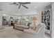 Open-concept living room featuring tile flooring, a ceiling fan, and a view into a bright kitchen with stainless steel appliances at 378 Tennessee Ave, Crystal Beach, FL 34681