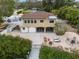 A charming home features a rear yard with brick pavers, a lounge area, and an upstairs balcony at 378 Tennessee Ave, Crystal Beach, FL 34681