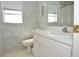 Bathroom featuring a single sink vanity with white cabinets, a toilet, and leaf patterned wallpaper at 3876 Darston St, Palm Harbor, FL 34685