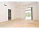 Bright bedroom with vaulted ceiling featuring sliding doors, neutral carpet and a ceiling fan at 3876 Darston St, Palm Harbor, FL 34685