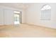 Bright bedroom featuring sliding doors, an arched window, neutral carpet and a ceiling fan at 3876 Darston St, Palm Harbor, FL 34685