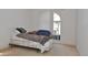 Bedroom featuring a window with blinds and carpet flooring, complete with bed and side table at 3876 Darston St, Palm Harbor, FL 34685
