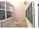 Small enclosed outdoor area with tan walls and gravel, offering a private and low-maintenance space at 3876 Darston St, Palm Harbor, FL 34685