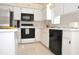 Well-lit kitchen with black appliances, white cabinets, and tile flooring, providing a practical cooking environment at 3876 Darston St, Palm Harbor, FL 34685