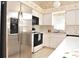 Bright kitchen with stainless steel refrigerator and white cabinets, creating a clean and functional cooking space at 3876 Darston St, Palm Harbor, FL 34685