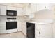 Practical kitchen featuring white cabinets, laminate countertops, black appliances, and easy-to-clean tile floors at 3876 Darston St, Palm Harbor, FL 34685