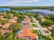 Stunning aerial view of home with pool, tile roof, and lake views in a desirable neighborhood at 3909 Tarian Ct, Palm Harbor, FL 34684
