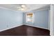 Bedroom with blue walls, ceiling fan, hardwood floors, window, and neutral accents at 408 S Arrawana Ave # B4, Tampa, FL 33609