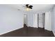 Spacious bedroom features dark wood floors, a ceiling fan, and a closet with white curtain doors at 408 S Arrawana Ave # B4, Tampa, FL 33609