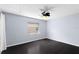 Well-lit bedroom with dark wood floors, a ceiling fan, and a large window, creating a comfortable space at 408 S Arrawana Ave # B4, Tampa, FL 33609