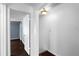 View of the hallway leading to a bedroom with brown wood floors and blue walls through a partially open door at 408 S Arrawana Ave # B4, Tampa, FL 33609