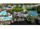 Beautiful aerial shot of community pool and tennis courts alongside lush landscaping and a tranquil pond at 4250 Warwick Hills Dr, Wesley Chapel, FL 33543