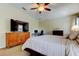 Bright bedroom featuring a comfortable bed, a dresser, and a dedicated workspace for rest and productivity at 4250 Warwick Hills Dr, Wesley Chapel, FL 33543