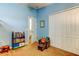 Bright bedroom offering a chair and closet and with a blue accent wall at 4250 Warwick Hills Dr, Wesley Chapel, FL 33543