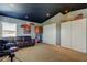 Bonus room with black ceiling featuring a comfortable leather sofa, closet, and built-in storage at 4250 Warwick Hills Dr, Wesley Chapel, FL 33543