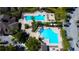 Aerial view of a community pool complex with lounge chairs, palm trees, and a clubhouse at 4250 Warwick Hills Dr, Wesley Chapel, FL 33543