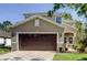 Charming two-story home featuring a two-car garage, lovely front lawn, and inviting entryway at 4250 Warwick Hills Dr, Wesley Chapel, FL 33543