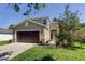 Charming two-story home with a well-maintained lawn, brown garage door, and inviting entryway, offering curb appeal at 4250 Warwick Hills Dr, Wesley Chapel, FL 33543