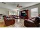 Comfortable living room with plush leather seating, a ceiling fan, and lots of windows bringing the outdoors in at 4250 Warwick Hills Dr, Wesley Chapel, FL 33543