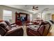 Inviting living area with plush leather seating, ceiling fan, and a large entertainment center for comfortable relaxation and entertainment at 4250 Warwick Hills Dr, Wesley Chapel, FL 33543