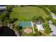 Scenic aerial view of a park with a basketball court, playground, and picnic area next to a pond at 4250 Warwick Hills Dr, Wesley Chapel, FL 33543