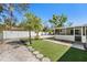 Artificial grass, stone pathway, and mature trees in backyard at 4846 Highland S St, St Petersburg, FL 33705