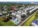 Aerial view highlights the townhomes, a community pool, manicured lawns and some mature trees at 5502 Liberty Plain Cir, Tampa, FL 33611
