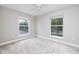 Light-filled bedroom featuring neutral carpet, ceiling fan, and two large windows at 5502 Liberty Plain Cir, Tampa, FL 33611