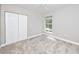 Bedroom features neutral carpet, a closet and a large window at 5502 Liberty Plain Cir, Tampa, FL 33611