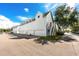 Exterior side view of a modern two story townhome with a light gray paint scheme, a gabled roof, and multiple garages at 5502 Liberty Plain Cir, Tampa, FL 33611