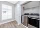 Laundry room with stainless steel washer and dryer, window, and shelf for storage at 5502 Liberty Plain Cir, Tampa, FL 33611