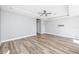Open living room featuring hardwood floors, tray ceiling with fan, and neutral paint at 5502 Liberty Plain Cir, Tampa, FL 33611