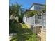 Spacious, grassy backyard with tropical landscaping and a white fence for added privacy at 625 Mirabay Blvd, Apollo Beach, FL 33572