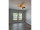Cozy bedroom with wood-look floors, a ceiling fan and bright natural light from the large windows at 625 Mirabay Blvd, Apollo Beach, FL 33572
